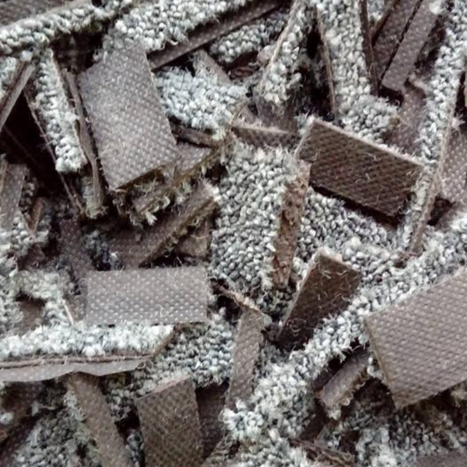 Close-up of recycled carpet fibre pieces used in equestrian arena surfaces.